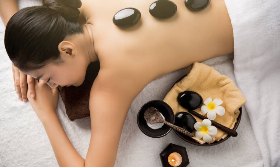 Women on massage table with stones on her back