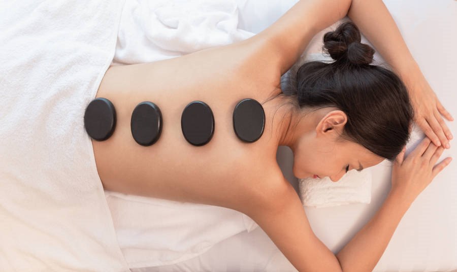 Women on massage table with stones on her back